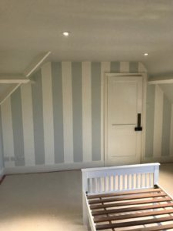 Hand-painted stripes in progress on a bedroom wall